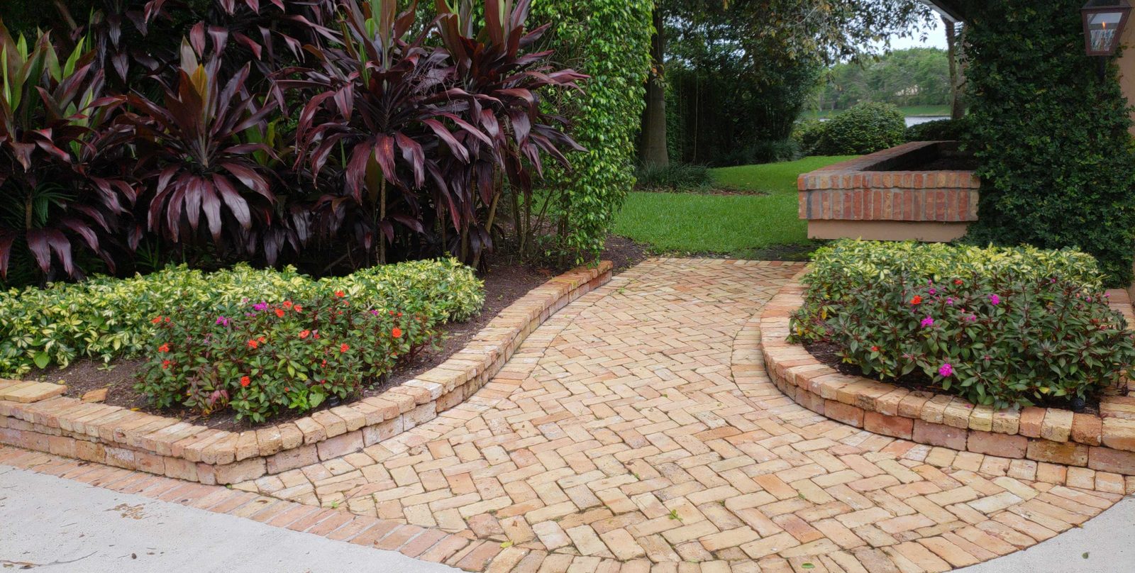 Brick paver walkway with curved raised planting beds
