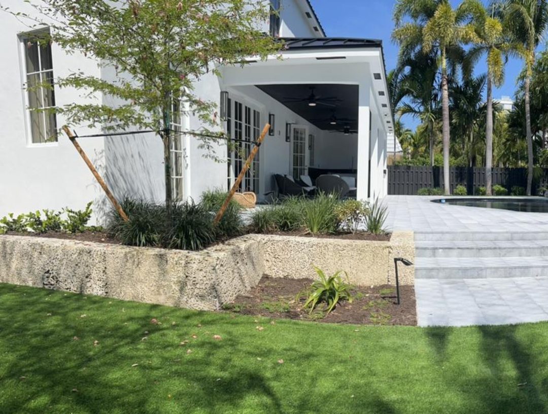 Coral-stone planter walls, artificial turf and pool deck steps