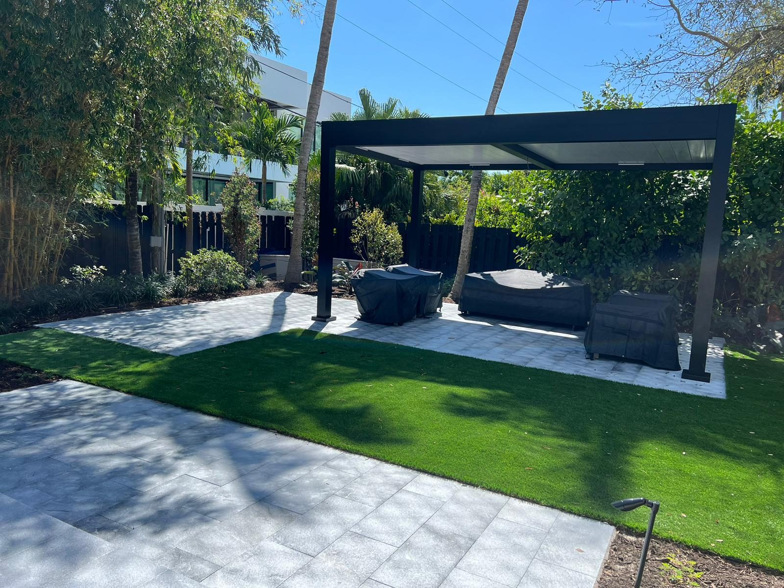 Backyard pergola terrace with stone pavers and artificial turf
