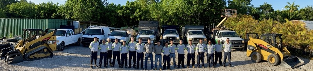Smart Choice crew in uniform in front of company trucks, bucket truck, skid steer and loader